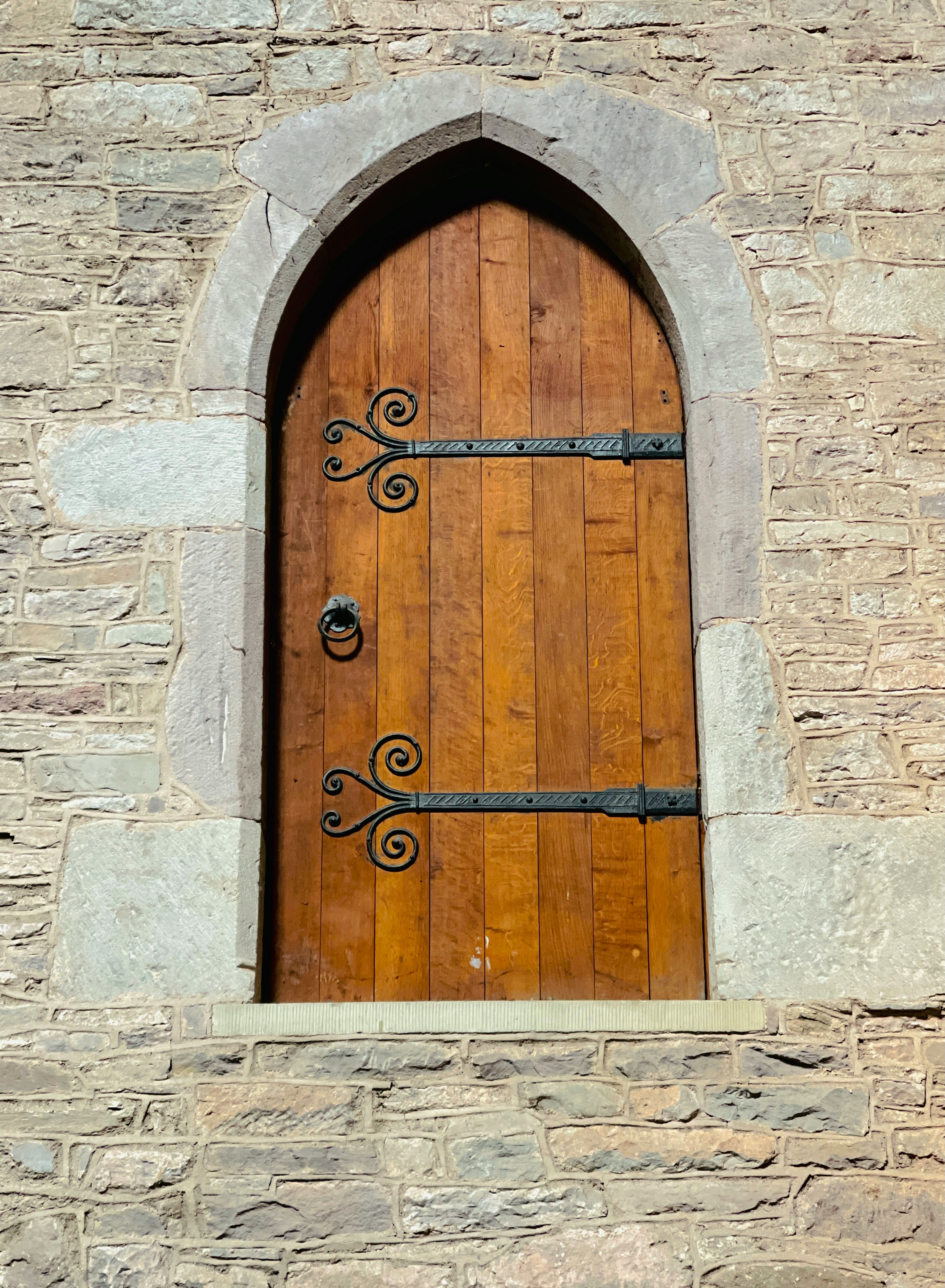 brown wooden door on gray brick wall